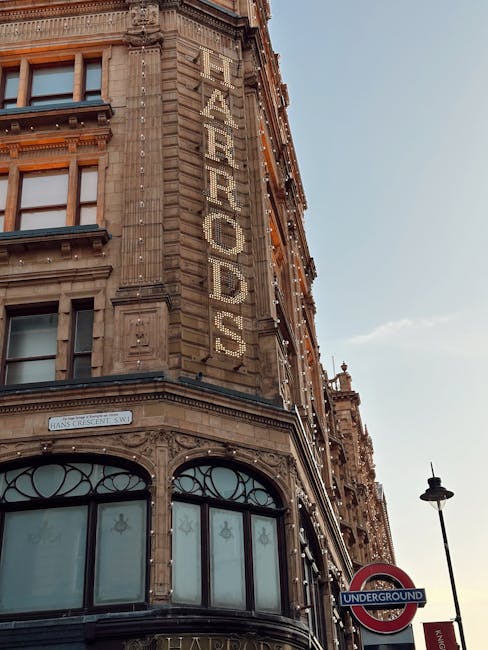 Photograph of a historic multi-storey building illuminated with warm exterior lighting during dusk in Knightsbridge, London. The building features ornate architectural details and large windows. Flank